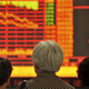 Investors look at an electronic board showing stock information at a brokerage house in Fuyang, Anhui province, China.
